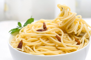 spaghetti with chili pepper and olive oil on white bowl