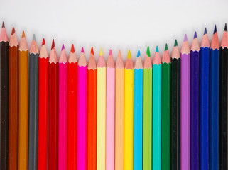 Assortment of coloured pencils with shadow on white background