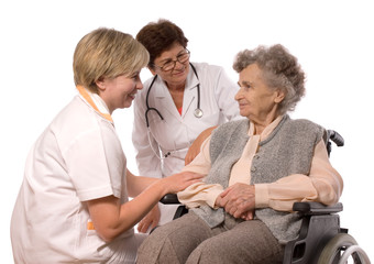 Health care workers and elderly woman in wheelchair