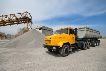 Fototapeta premium Delivery of granite crushed stone by conveyor to the loading warehouse by a heavy-duty dump truck.