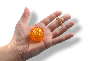 Hand with a ball for massage of orange color.