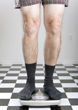 Man In Underwear And Socks Standing On A Scale.