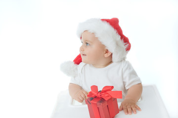 little, cute baby boy wearing Christmas hat, on white