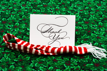 Thank you card and striped scarf on leaf and holly berry