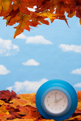 Fall leaves with blue clock , fall back time change