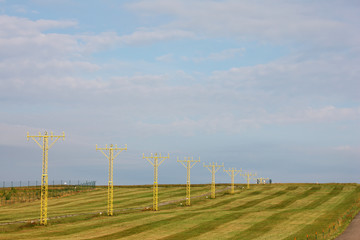 Fototapeta na wymiar yellow runway airport ILS lamps grass and sky