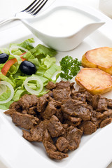 Grilled meat with baked potatoes, sauce and vegetable salad