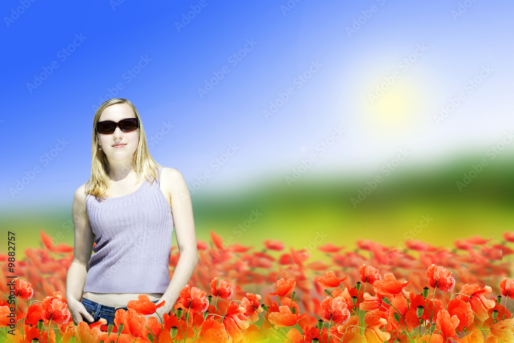 Wall mural woman standing on poppy flowers field