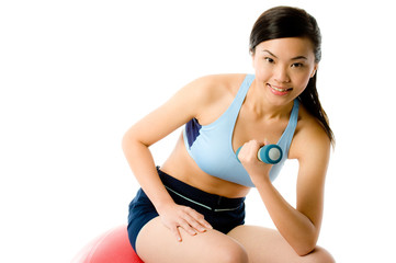 A young attractive Asian woman working out with dumbbells
