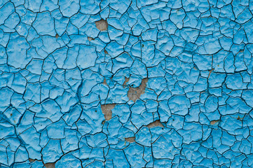 cracked surface of blue paint outdoors