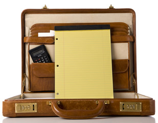 A brown leather briefcase with a blank legal tablet
