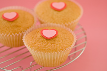 Cupcakes with heart symbols on a wire rack