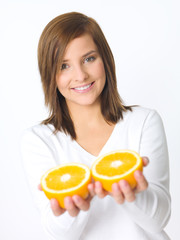 Portrait of beautiful young woman holding fresh orange fruit