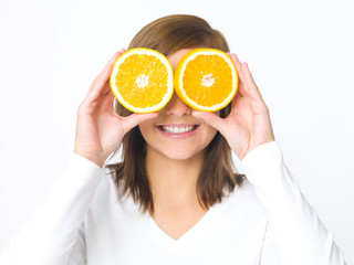 Portrait of beautiful young woman holding fresh orange fruit
