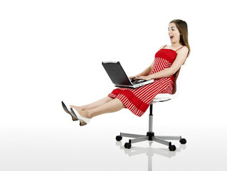 happy woman seated on a chair with a laptop