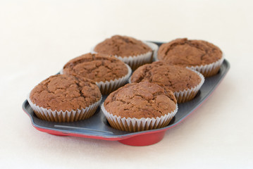 Freshly baked muffins still warm in the tray