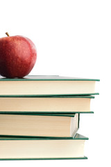 A red apple on top of many books on a white background