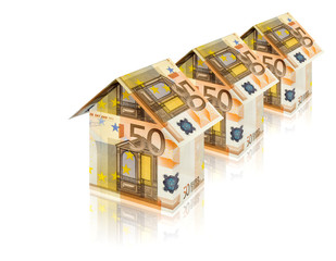 three houses built of euro bills with reflection on white