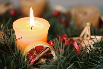 Detail of christmas advent wreath with burning candle.