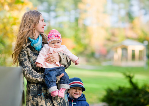 Young mother with two kids enjoying beautiful autumn day