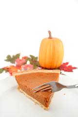 taking a piece of pumpkin pie with fork with autumn leaves,