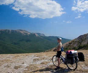 Fototapeta premium Woman travel with bike in Crimea mountains.
