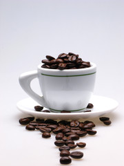 white color  cup and  plate filled with grains of coffee