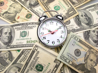 Dollar banknotes and clock, close up