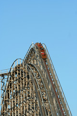 A wooden roller coaster against blue sky