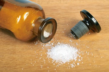 Brown glass bottle with spilled white powder