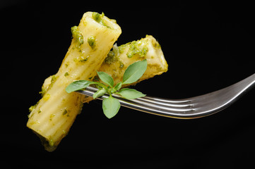 Italian pasta with pesto on fork isolated on black