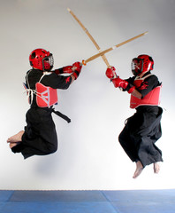 Two martial arts practicing fighting with wood swords