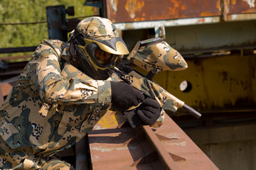 Paintball player in camouflage uniform outdoors