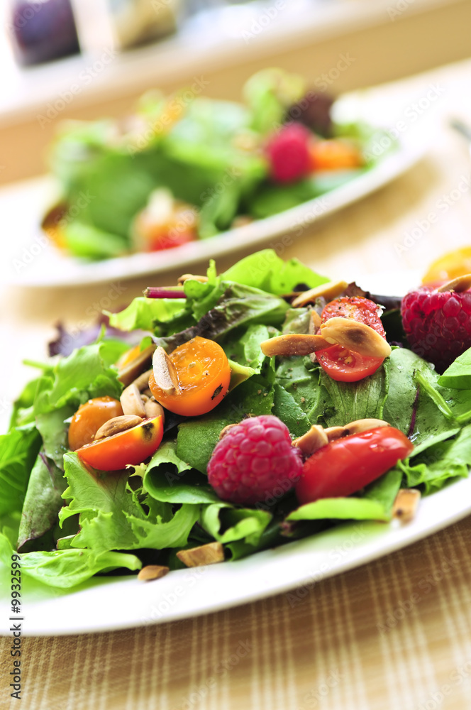 Wall mural healthy green salad with berries and cherry tomatoes