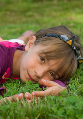 petite fille se reposant dans l'herbe verte