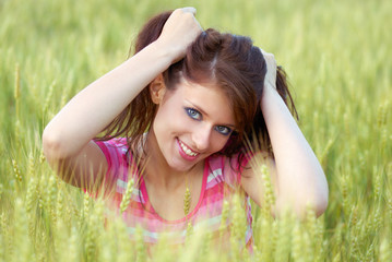 Portrait of the beautiful girl in wheat field
