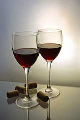 Two glasses with red wine with bottle corks