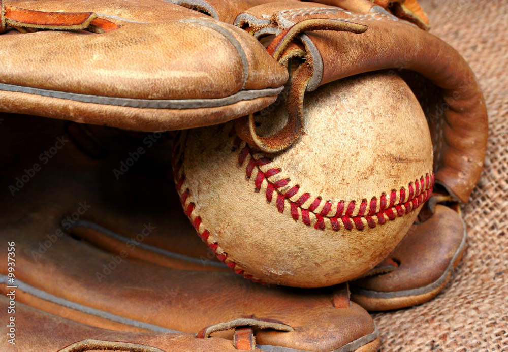 Canvas Prints Worn and used baseball in the pocket of a baseball mitt.