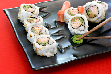 Japanese  Sushi on square plate with chopsticks.