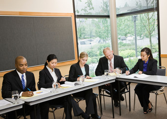 Multi-ethnic co-workers sitting around table in conference room
