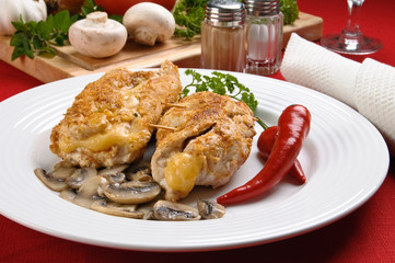 Stuffed fried chicken fillets with cheese, ham, and vegetables