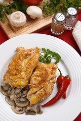 Stuffed fried chicken fillets with cheese, ham, and vegetables