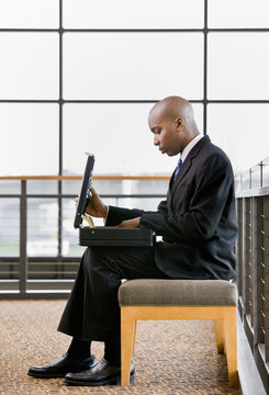 African businessman looking in briefcase in office lobby