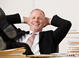 Relaxed businessman at desk with feet up