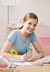 Obraz na płótnie Canvas Determined girl doing homework in bedroom