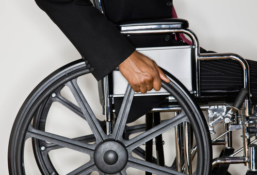 Disabled businessman pushing himself in wheel chair