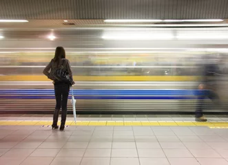Selbstklebende Fototapeten Einsame Frau, die U-Bahn-Geschwindigkeit vorbei beobachtet. © Barbara Helgason