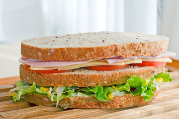 submarine sandwich with whole grain bread on wood platter