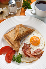 Breakfast - toasts, egg, bacon and vegetables