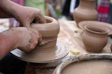 Potter hands making cley pot on turning table